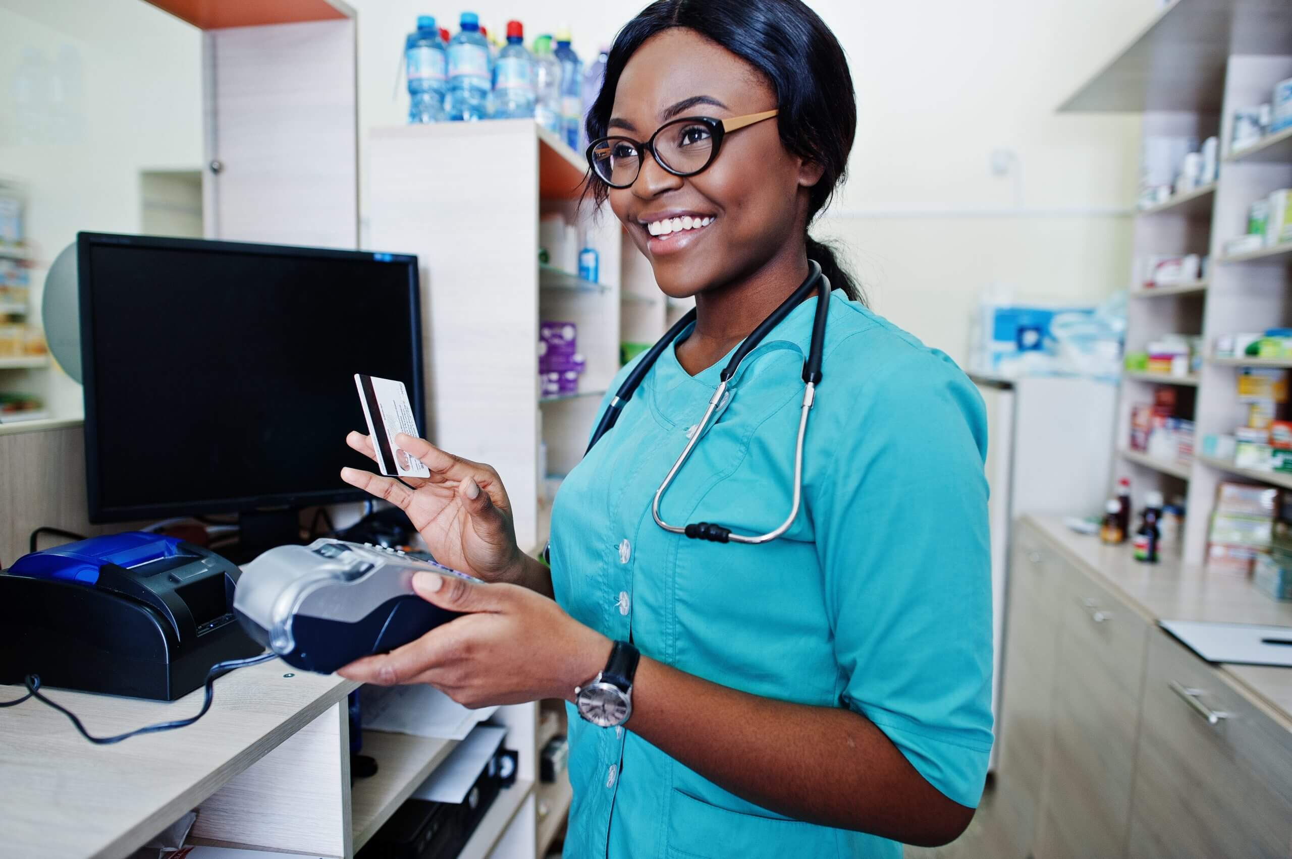 African american pharmacist working in drugstore at hospital pharmacy. African healthcare. Work with payment terminal and credit card.